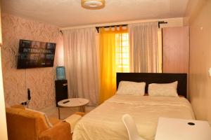 a bedroom with a bed and a table and a chair at Divinehomes in Nairobi