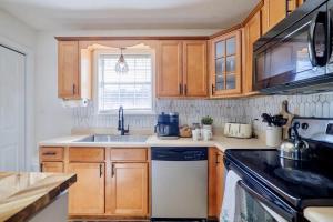 a kitchen with wooden cabinets and a sink and a stove at FAMILY Friendly Sleeps 10 4 Bedrooms King Bed & Pets in Valdosta +22 photos