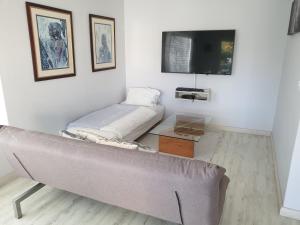 a living room with a couch and a flat screen tv at Junior-Suite Merlot in Cape Town
