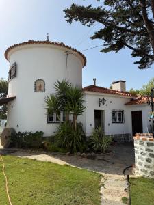 a white house with a tree in front of it at Moinho da Saudade in Alcabideche
