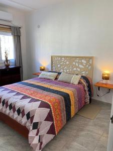 a bedroom with a bed with a colorful blanket at Clomplejo MUNAY con piscina y parking in Villa Cura Brochero +55 photos