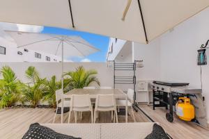 een eetkamer met een tafel en stoelen en een parasol bij Private Villa in Punta Cana with Pool and Jacuzzi in Punta Cana