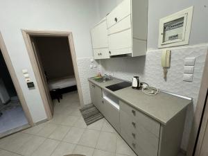 a kitchen with white cabinets and a sink and a phone at cozy minimal apartment in Piraeus +29 photos
