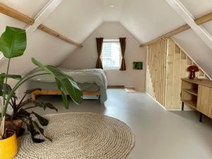 1 dormitorio en el ático con 1 cama y una maceta en Casa aan de vecht, en Ons Belang