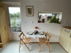 Una mesa y dos sillas en una habitación con ventana. en Casa aan de vecht, en Ons Belang