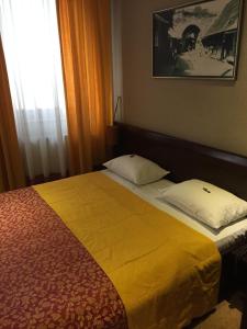 a bedroom with a bed with a yellow blanket at Hotel Stari grad in Jajce