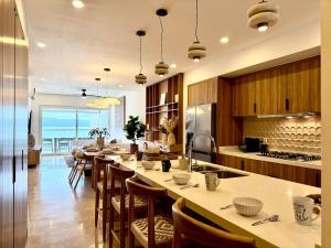 a large kitchen with a long table and chairs at Harbor NT507 by Moikkarentals in Puerto Vallarta