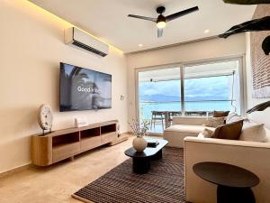 a living room with a couch and a tv at Harbor NT507 by Moikkarentals in Puerto Vallarta
