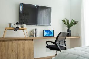 a bedroom with a chair and a television on a wall at High Park 94 by Jalo in Bogotá