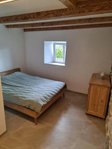 VilarsAu petit nid的一间卧室设有一张床和一个小窗口