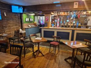 a restaurant with tables and chairs and a bar at The Old Victoria in Penrith