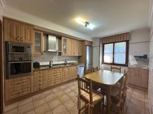 a kitchen with wooden cabinets and a table with chairs at Casa los 8 caños in Ezcaray