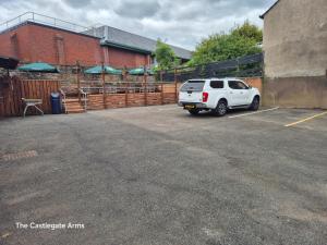 a white suv parked in a parking lot next to a building at The Old Victoria in Penrith +1 photo