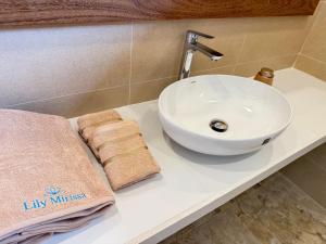 a sink and towels on a counter in a bathroom at Lily Mirissa in Mirissa