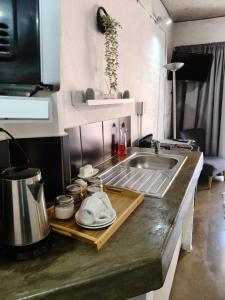 a kitchen with a sink and a counter with dishes at Stylish Modern Apartment in the heart of Maboneng, Free Wifi and Netflix in Johannesburg +13 photos