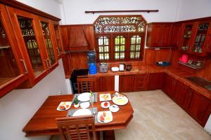 a kitchen with wooden cabinets and a table with food on it at Aetos Wellness - Tangalle in Tangalle