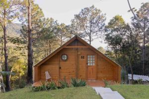 a log cabin with a clock on the door at Chalés do Tabuleiro, Chalé 2 in Palhoça