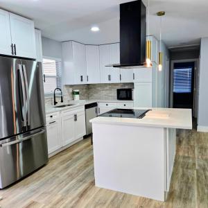 a kitchen with white cabinets and a stainless steel refrigerator at Vacation Home in Bradenton