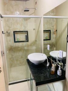 a bathroom with a glass shower and a sink at Casa com piscina in Marechal Deodoro