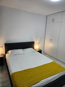 a bedroom with a large bed with a yellow blanket on it at Apartament 2 camere in Onești