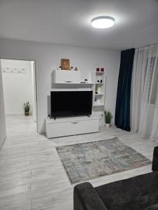 a living room with a flat screen tv on a white entertainment center at Apartament 2 camere in Onești