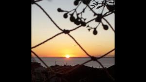 a sunset seen through a chain link fence at Santo Antônio Além do Carmo - apartamento com varanda e vista pro mar, até 3 pessoas in Salvador