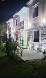 a person standing outside of a house at night at Bujtina Hakorja 1988 in Peshkopi