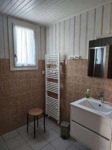 a bathroom with a sink and a mirror and a stool at Chez David et Julie in La Bouverie