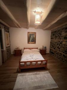 a bedroom with a bed and a painting on the wall at Bujtina Hakorja 1988 in Peshkopi +24 photos