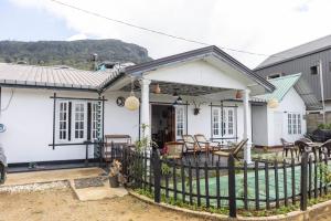 a white house with a fence in front of it at Snowdon in Nuwara Eliya