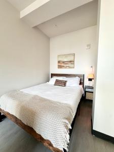 a bedroom with a large bed in a white room at Deer District Studio Apt - One Block from Fiserv and Baird in Milwaukee +15 photos