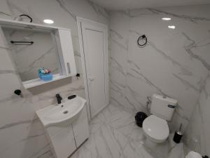 Un baño blanco con inodoro y lavabo. en Къща за гости Бела, en Targóvishte 33 fotos más