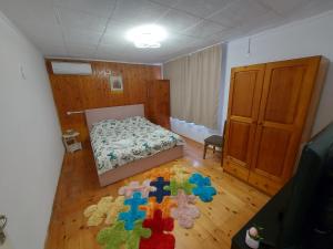 Un dormitorio con una cama y una alfombra en el suelo. en Къща за гости Бела, en Targóvishte