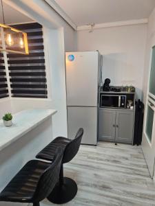 a kitchen with a white refrigerator and a chair at Luxury Studio in Onești