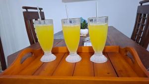 two glasses of orange juice sitting on a wooden table at Aetos Wellness - Tangalle in Tangalle +12 photos