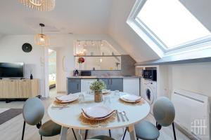 Una cocina con una mesa y sillas en una habitación. en Le Mirabeau - Gare à 100m - Wifi - Bureau - 2 V, en Saint-Pierre-des-Corps 25 fotos más