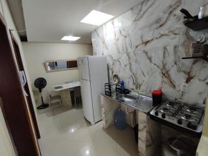 a kitchen with a stove and a white marble wall at Suíte Nazaré in Belém