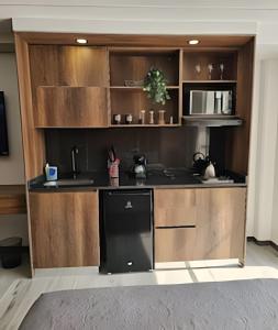 a kitchen with wooden cabinets and a black refrigerator at Epic Suite 209 Deluxe Aeropuerto in Cuba