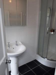 a bathroom with a sink and a shower at Small bedroom for 3 people in London
