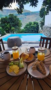 a table with plates of food and glasses of orange juice at Casa Terras do Douro in Vacalar