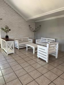 una habitación con tres bancos blancos y una mesa en Atterbury Value Bed and Breakfast, en Pretoria
