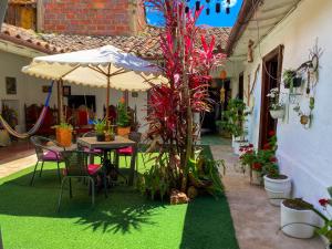 a patio with a table and umbrella and plants at CASA MAGIA by Magally Velasco in Curití