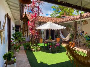 un patio con una mesa y una sombrilla en CASA MAGIA by Magally Velasco, en Curití