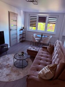 een woonkamer met een bank en een tafel bij Feliz Stay in Šiauliai