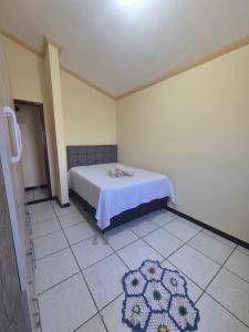 a bedroom with a bed and a tiled floor at Flat MP PLUMA 201A in Araxá