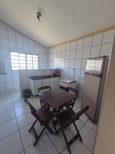 a kitchen with a table and chairs and a refrigerator at Flat MP PLUMA 201A in Araxá