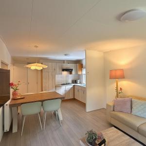 a kitchen and living room with a table and a couch at Ermwood Cottage in Erm