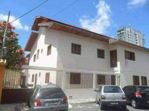 a white house with cars parked in front of it at Suíte Nazaré in Belém