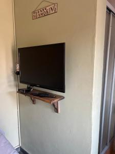 a computer monitor on a shelf on a wall at ForgetMeNot Guesthouse Lydenburg in Lydenburg +4 photos