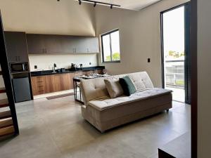 a living room with a couch and a kitchen at Lofts completos em Sinop MT in Sinop